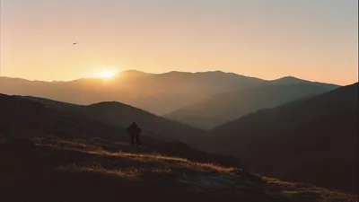 Silhouette in mountain landscape at sunrise.