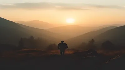 Silhouette in mountain landscape at sunrise.