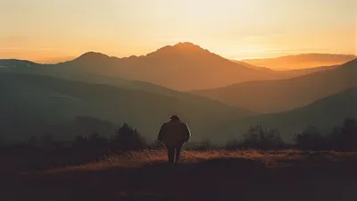 Silhouette in mountain landscape at sunrise.
