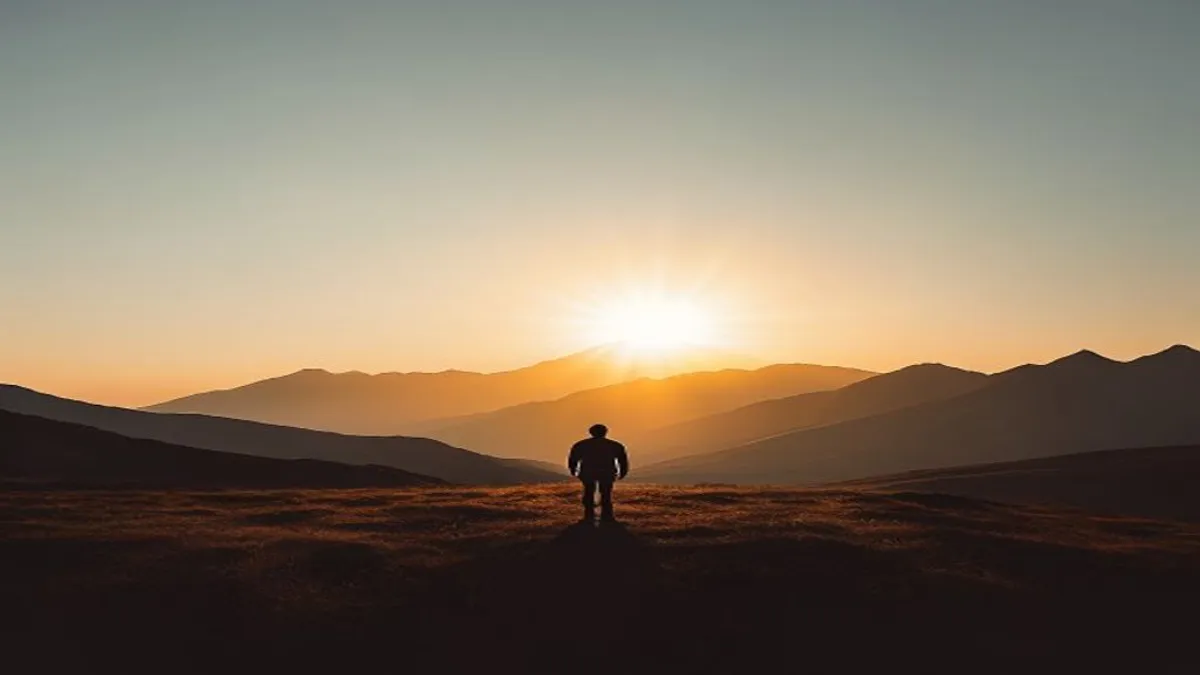 Silhouette in mountain landscape at sunrise.