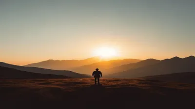 Silhouette in mountain landscape at sunrise.