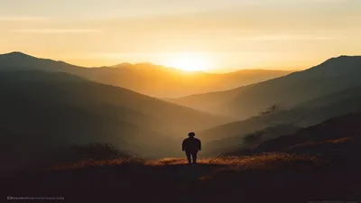 Silhouette in mountain landscape at sunrise.