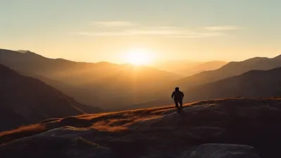 Silhouette in mountain landscape at sunrise.