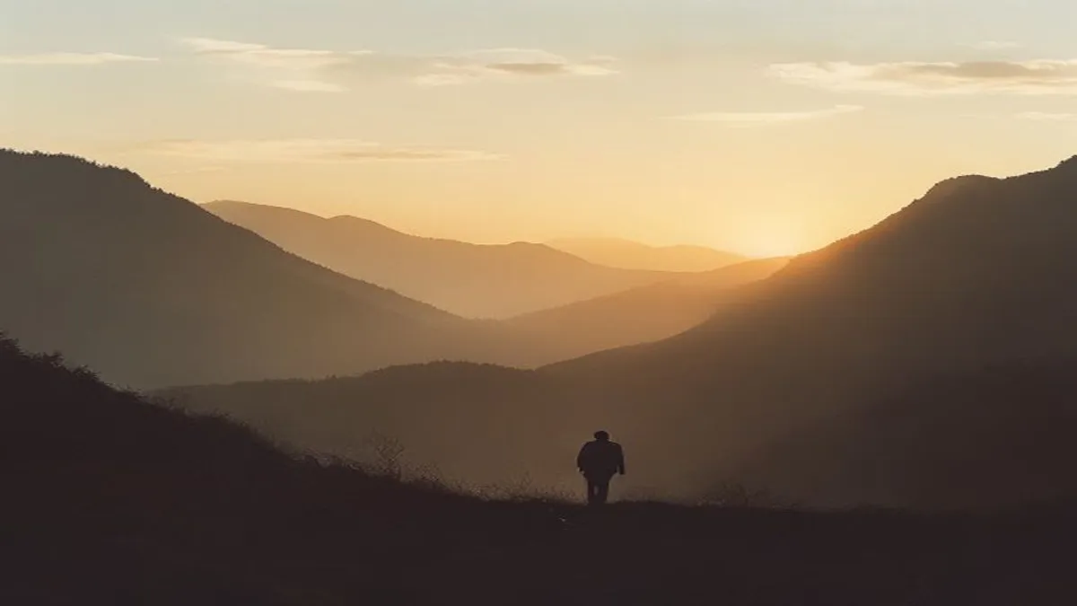 Silhouette in mountain landscape at sunrise.