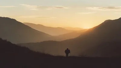 Silhouette in mountain landscape at sunrise.