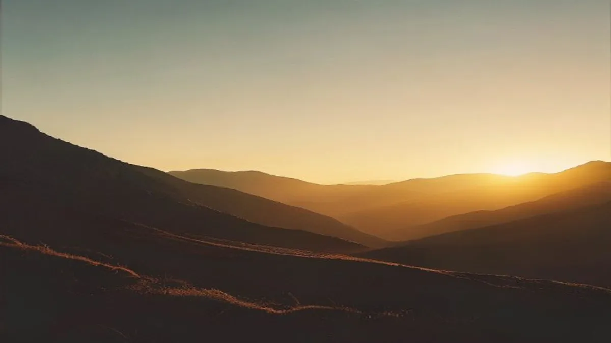 Silhouette in mountain landscape at sunrise.