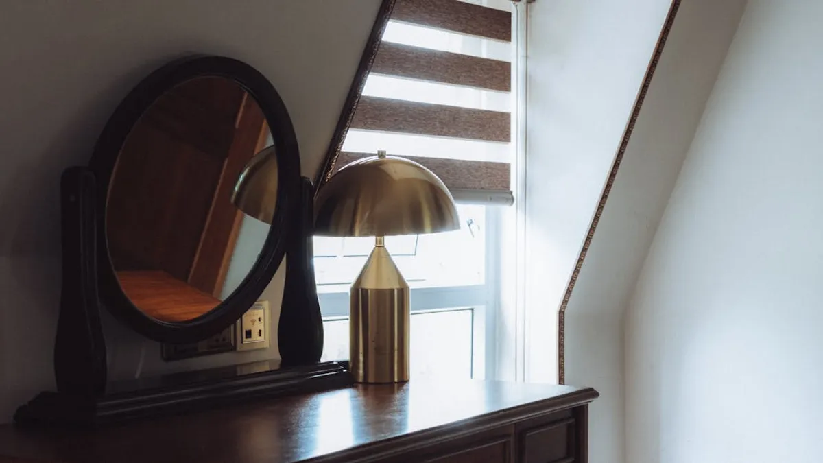 Elegant interior scene featuring a vintage mirror and brass lamp on a wooden table by a window.