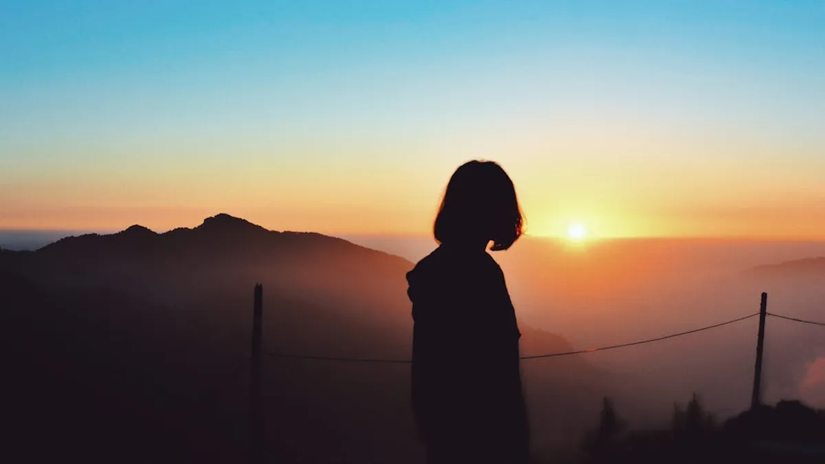 A peaceful silhouette of a woman watching the sunrise over the hills in Nainital, India.